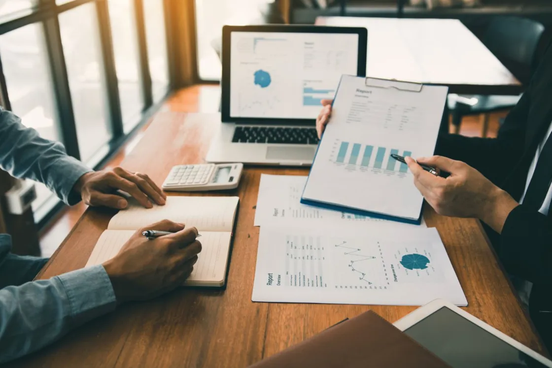 Printed reports, laptop and charts laid out for a review